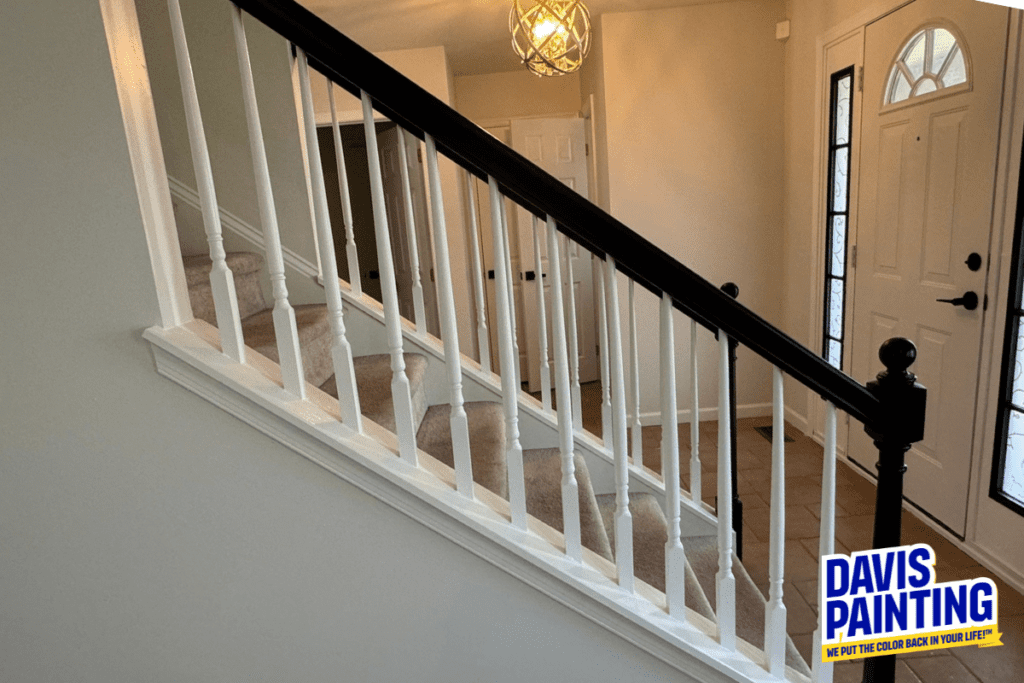 Foyer stairs and railing going to the second floor. Railing is painted black and rungs white.