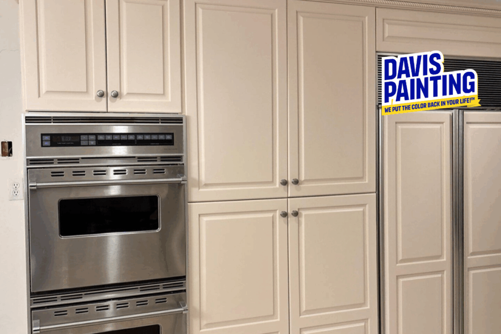 Cream-colored kitchen cabinets with stainless steel double ovens built in; a "Davis Painting" logo with the tagline "We put the color back in your life!" is in the upper right corner.
