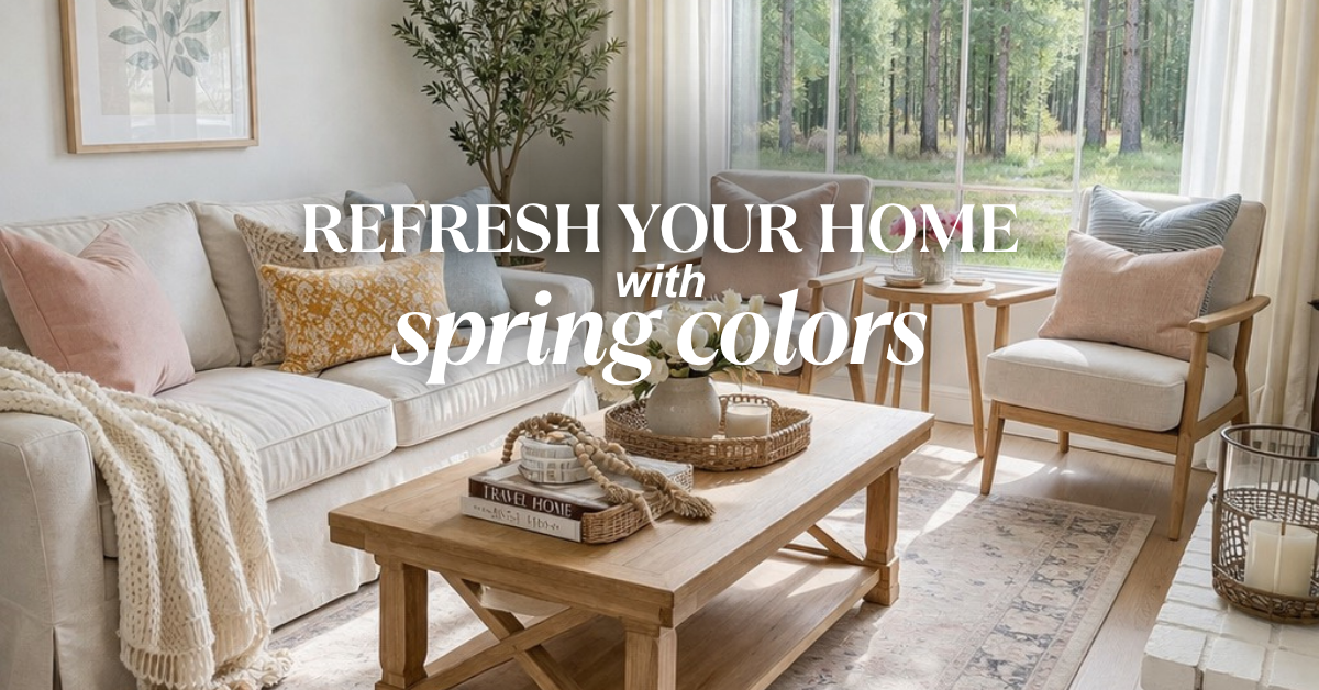 A bright living room with neutral furniture, pastel throw pillows, a wooden coffee table with decor items, large windows with sheer curtains, and green trees visible outside. Text reads: "Refresh your home with spring colors.
